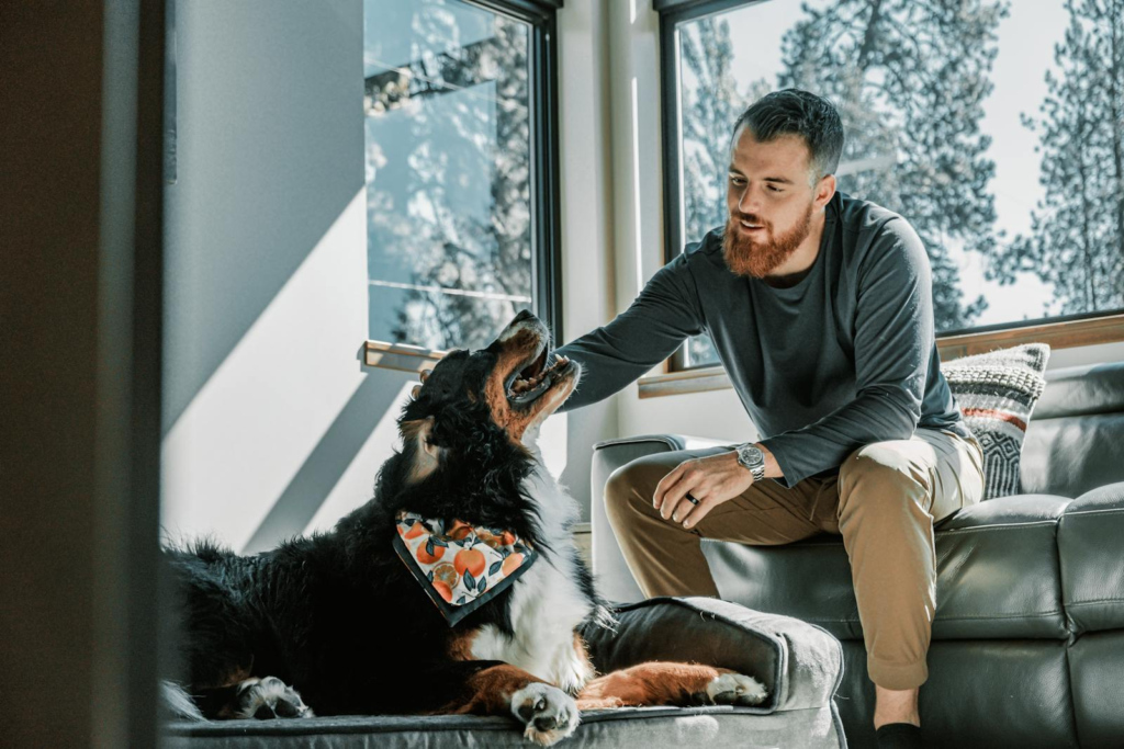 Finding the Perfect Dog Sitter in Franconia, VA 7 A man enjoys a moment with his Bernese mountain dog indoors, capturing warmth and companionship.